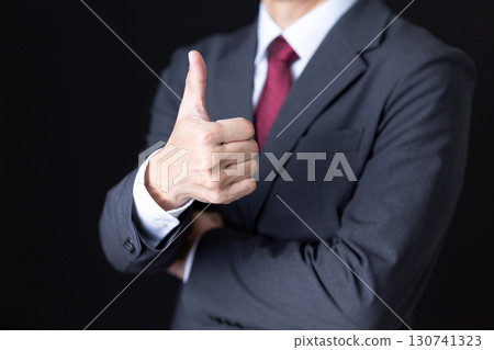 A middle-aged male businessman in a suit giving a thumbs-up A middle-aged male businessman in a suit giving a thumbs-up 130741323