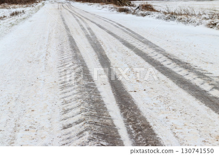 Tire tracks on icy road covered with snow Tire tracks on icy road covered with snow 130741550