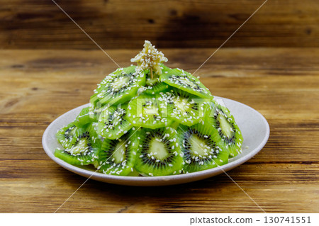 Christmas tree shaped fruit salad on wooden table. Creative idea for Christmas and New Year festive desserts. Funny food idea for kids 130741551
