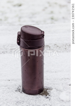 Thermo mug on a snow covered table at winter Thermo mug on a snow covered table at winter 130741561