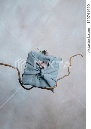 A furoshiki wrapped box on tree branch in front of the wall 130741660