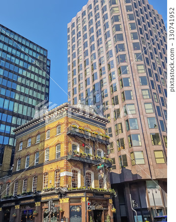 LONDON, UNITED KINGDOM - APRIL 15, 2023 Street view of The Albert pub in London, a striking vintage Victorian style building contrasting with the modern high-rise constructions LONDON, UNITED KINGDOM - APRIL 15, 2023 Street view of The Albert pub in London, a striking vintage Victorian style building contrasting with the modern high-rise constructions 130741952