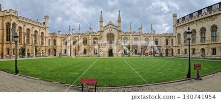 The University of Cambridge panoramic view of a historic college courtyard, featuring a grand, symmetrical facade with Gothic inspired architecture and a central clock tower The University of Cambridge panoramic view of a historic college courtyard, featuring a grand, symmetrical facade with Gothic inspired architecture and a central clock tower 130741954