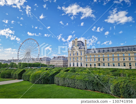 The Tuileries Garden with view to the Grande Roue in Paris, France. The famous Ferris wheel is visible on the left of the historic Louvre Palace 130741956
