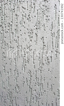 Textured gray concrete wall with vertical ridges and rough surface patterns 130741992