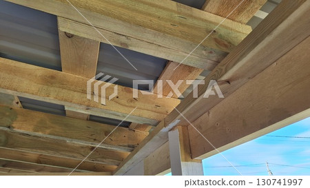 Wooden roof structure with metal sheeting and daylight view Wooden roof structure with metal sheeting and daylight view 130741997