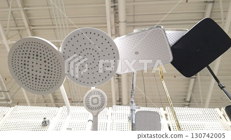 Assorted modern showerheads displayed on rack in store interior 130742005