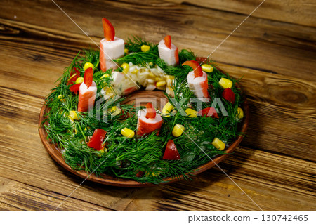Salad Christmas wreath on a wooden table 130742465