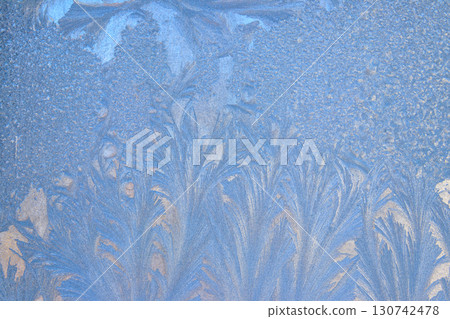 Frost pattern on a frozen window at winter. Natural background, texture Frost pattern on a frozen window at winter. Natural background, texture 130742478