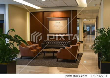 Elegant corporate office waiting area featuring comfortable seating and a prominently displayed mission statement 130742701