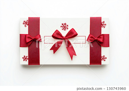 Christmas gift certificate mockup with red ribbon and bows lying on white background, ideal for holiday season marketing and promotion 130743960