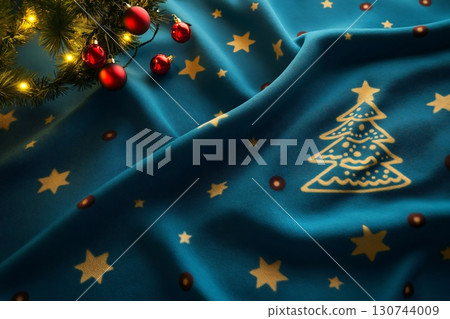 Christmas tree patterned blanket with lights and baubles providing a festive background 130744009