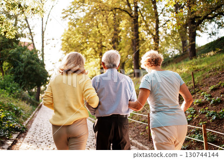 A Family Enjoying a Leisurely Walk in a Beautiful and Scenic Park This Autumn Season A Family Enjoying a Leisurely Walk in a Beautiful and Scenic Park This Autumn Season 130744144