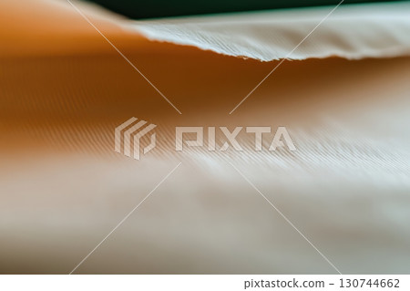 Close-up view of textured fabric in warm tones captured in bright light 130744662