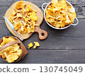 Raw Wild Chanterelle Mushrooms in wicker basket on dark gray wooden background on table few Chanterelle Mushrooms 130745049