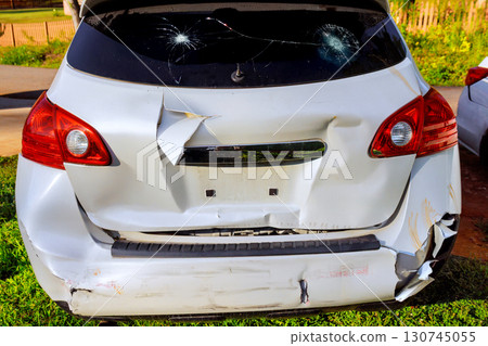 Parked vehicle shows significant rear damage with scratches, cracked lights Parked vehicle shows significant rear damage with scratches, cracked lights 130745055