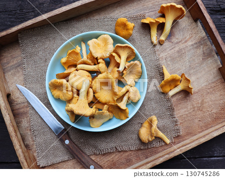 Bowl of chanterelle mushrooms on wooden background 130745286