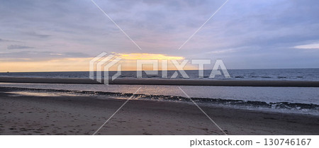 Sunset on the beach near beautiful sea in the evening. Yellow sunlight. Vacation in Ostend, Belgien. Sunset on the beach near beautiful sea in the evening. Yellow sunlight. Vacation in Ostend, Belgien. 130746167