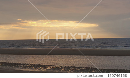 Sunset on the beach near beautiful sea in the evening. Yellow sunlight. Vacation in Ostend, Belgien. Nature background. Sunset on the beach near beautiful sea in the evening. Yellow sunlight. Vacation in Ostend, Belgien. Nature background. 130746168