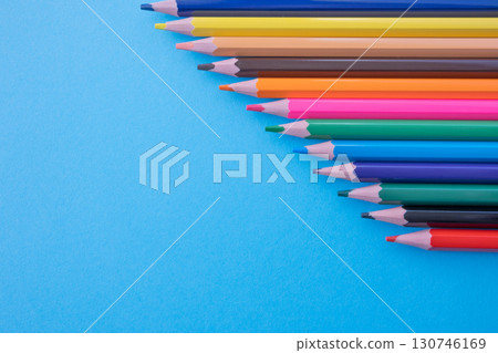 A lot of color pencils on the bright blue paper background. Close up. Design concept. Space for text. A lot of color pencils on the bright blue paper background. Close up. Design concept. Space for text. 130746169