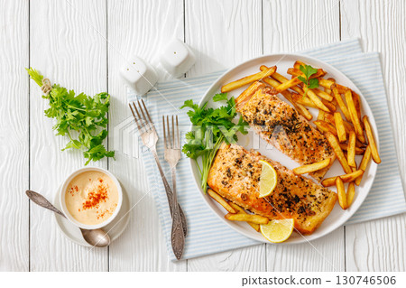 Baked salmon fillet with french fries on plate 130746506
