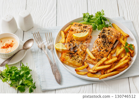 Baked salmon fillet with french fries on plate Baked salmon fillet with french fries on plate 130746512