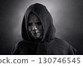 Portrait of a scary man in hooded cloak at night over dark misty background  130746545