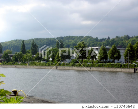 Regensburg Serene Riverside View Along the Danube With Lush Greenery and Calm Waters 130746648