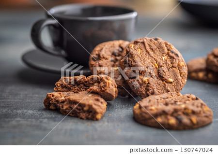 Sweet chocolate cookies and coffee cup on kitchen table. Sweet chocolate cookies and coffee cup on kitchen table. 130747024