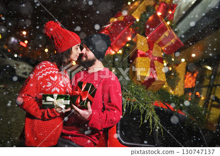 two lovers with gifts in their hands kiss against the backdrop of snow and celebrate Valentine's Day two lovers with gifts in their hands kiss against the backdrop of snow and celebrate Valentine's Day 130747137