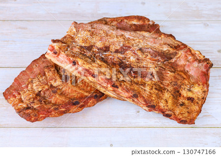 Smoked flavorful ribs are seasoned cooked to perfection, showcasing delicious crust smoky aroma. Smoked flavorful ribs are seasoned cooked to perfection, showcasing delicious crust smoky aroma. 130747166