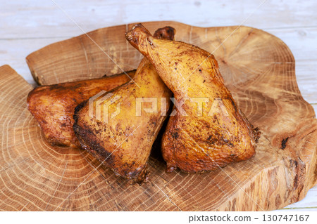 Smoked chicken legs are beautifully presented on wooden board, their golden brown smoky flavor. Smoked chicken legs are beautifully presented on wooden board, their golden brown smoky flavor. 130747167