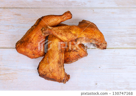 Deliciously seasoned smoked chicken legs displayed on weathered wooden table 130747168
