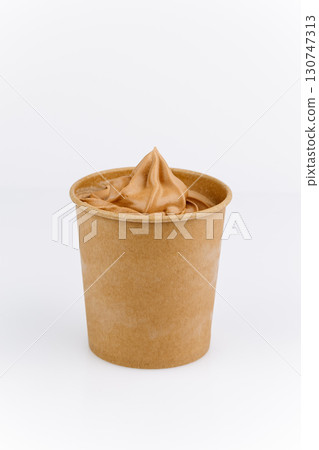 Chocolate soft serve ice cream in eco paper cup on white background, minimal design Chocolate soft serve ice cream in eco paper cup on white background, minimal design 130747313
