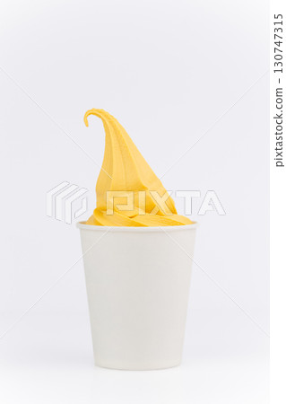 Yellow mango ice cream swirl in white paper cup on clean white background, close up 130747315
