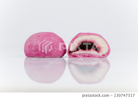 Pink mochi ice cream with berry filling, cut in half, isolated on white background 130747317