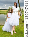 Mother and daughter in white in nature 130747414
