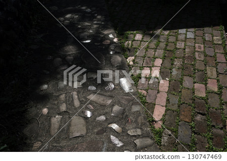 Light and shadow highlight the mosaic pattern on the road surface 130747469