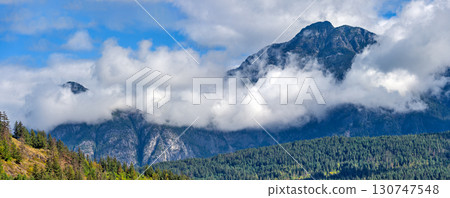 Mountain landscape view with clouds below the mountain's tops 130747548