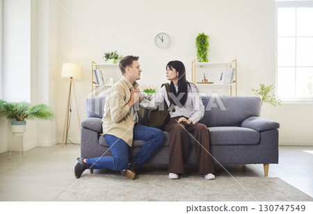 Man and woman in tense conversation on living room sofa with emotion and conflict 130747549