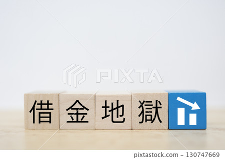 Image of wooden blocks representing debt trap and a downward arrow 130747669