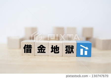 Image of wooden blocks representing debt trap and a downward arrow 130747670