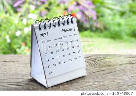 February 2027 desk calendar standing upright with blurred green background for office planning. 130748007