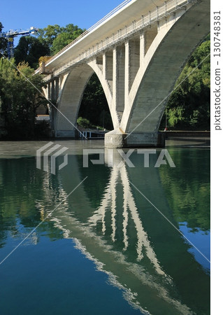 The confluence of the Rhône and Arve rivers in Geneva: bridge and reflections on the water 130748381