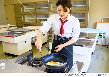 Female instructor teaching at cooking class. Image of cooking lesson and food education. Female instructor teaching at cooking class. Image of cooking lesson and food education. 130748444