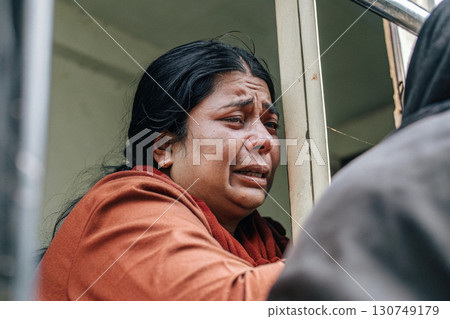 Sad Woman Crying Behind Metal Bars in Emotional Scene. 130749179