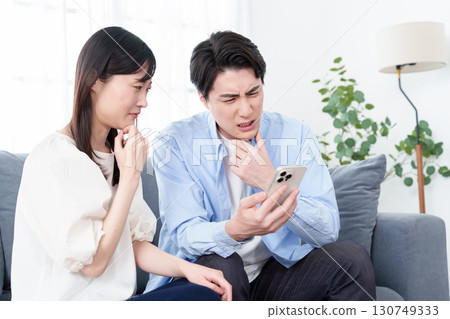 男人和女人帶著困惑的表情看著智慧型手機 男人和女人帶著困惑的表情看著智慧型手機 130749333