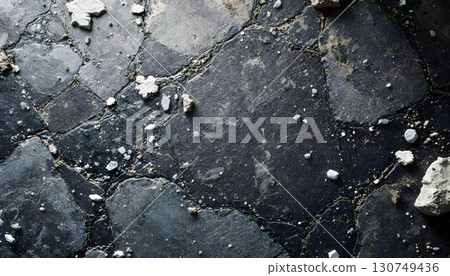 A detailed view of a granite rock wall showcases its intricate textures and the visible cracks that traverse its surface 130749436