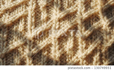 A close-up of a textured knitted sweater, with sunlight enhancing the intricate knit design 130749931