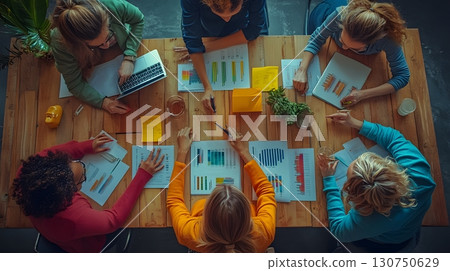 Business Women Analyzing Graphs During Office Meeting 130750629
